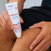 Personne appliquant le gel de massage OSTÉOCALM® GEL du Laboratoire Dielen sur son genou à l’aide de l’embout roll-on.