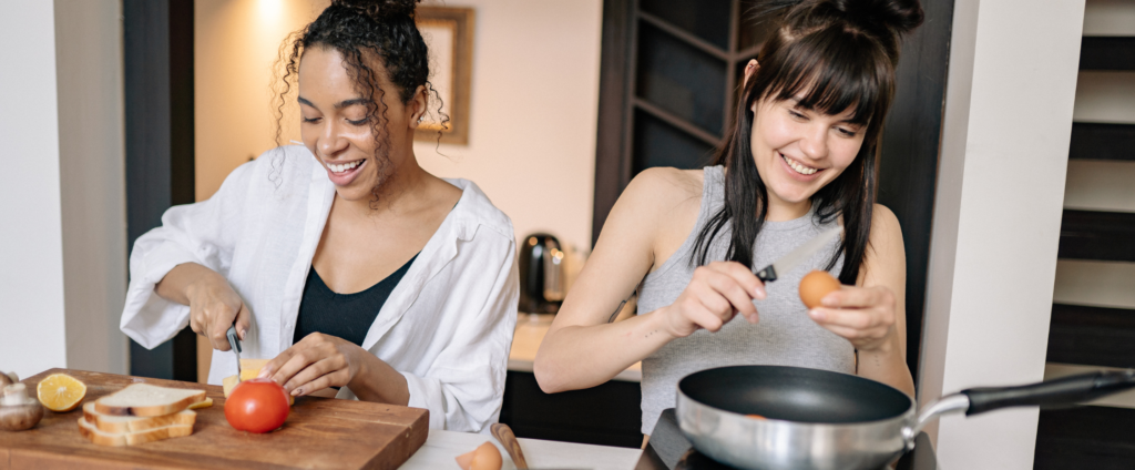 Deux femmes préparant un repas maison avec des aliments frais, illustrant de bonnes habitudes pour manger mieux au quotidien.