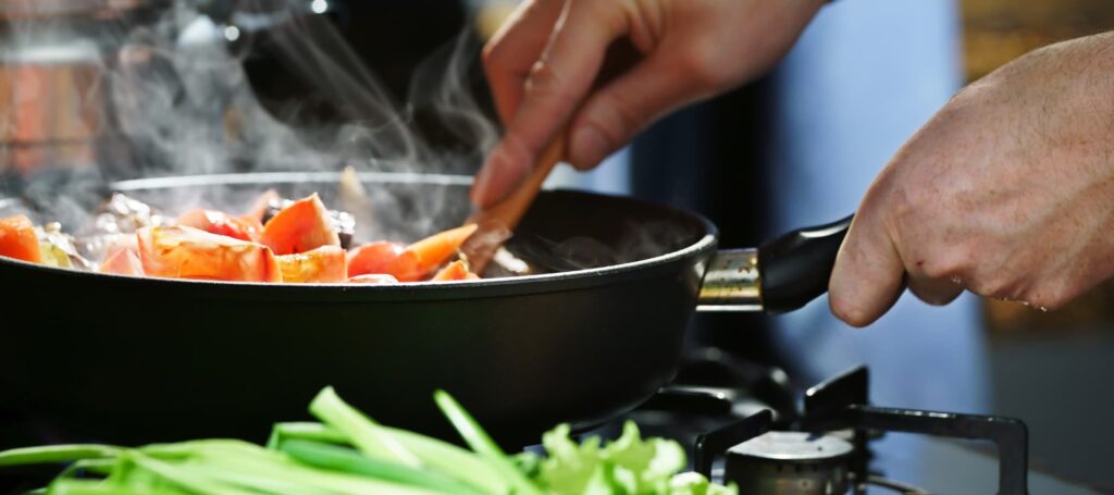 Poêlée de légumes frais en cours de cuisson dans une casserole, préparation maison saine