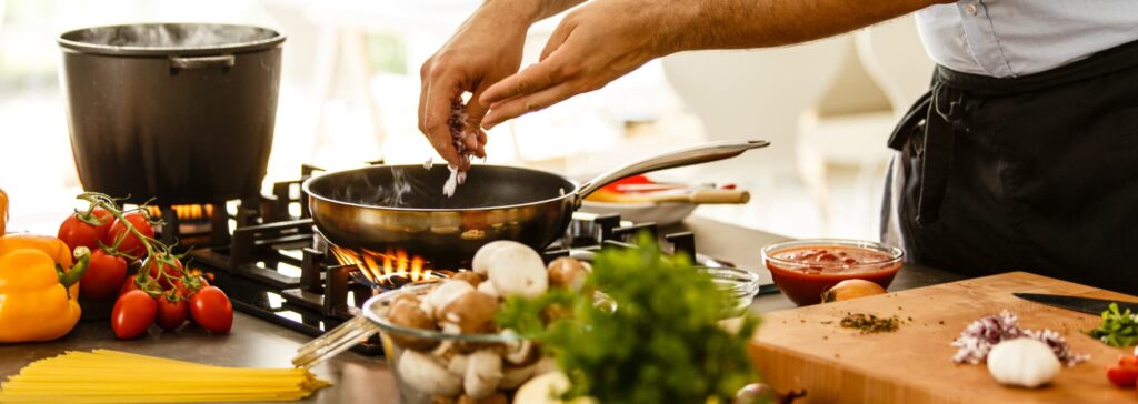 Préparation de pâtes maison avec cuisson à la poêle et ajout d’ingrédients frais en cuisine