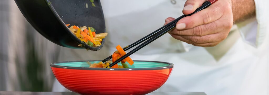 Service de légumes sautés au wok dans un bol avec des baguettes